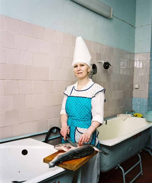 Employee preparing fish in the cement factory’s canteen, Angarsk, Russia